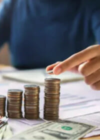 Person placing a coin on top of a stack of coins