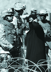 US Military members speaking with woman in Middle East